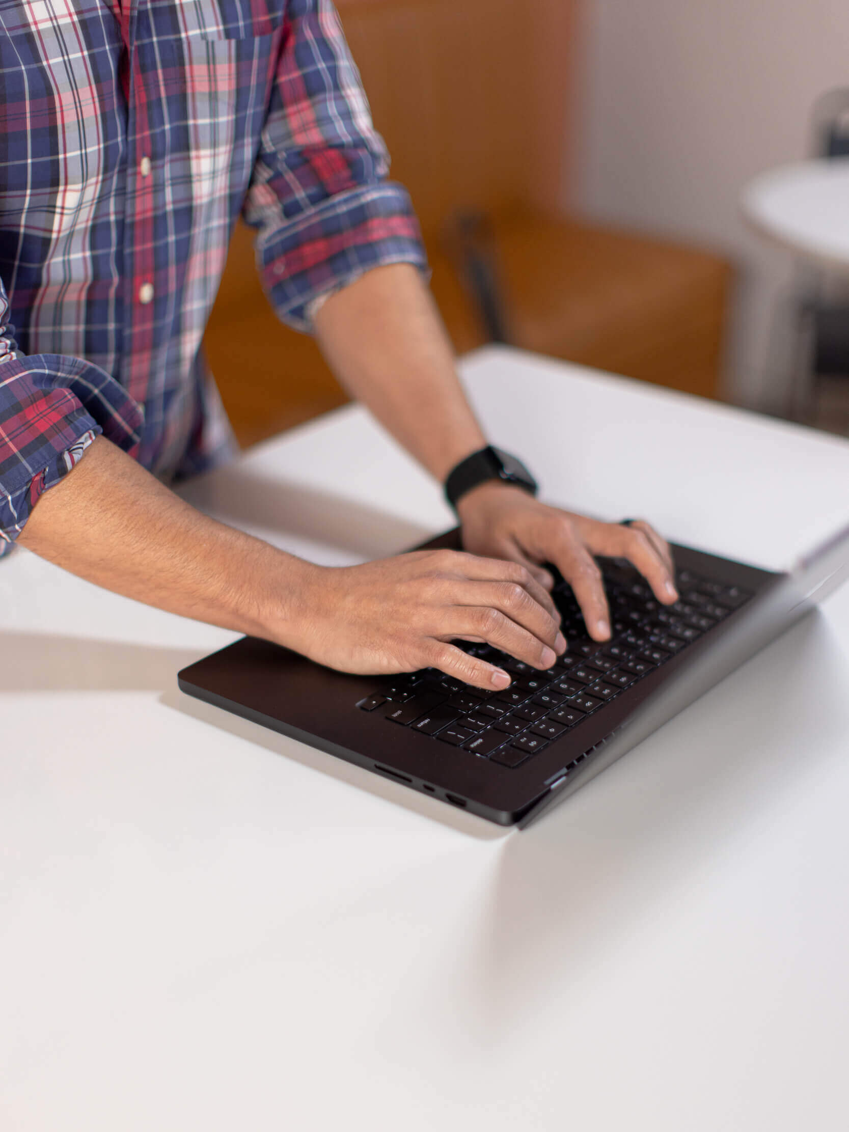Hands typing on a laptop