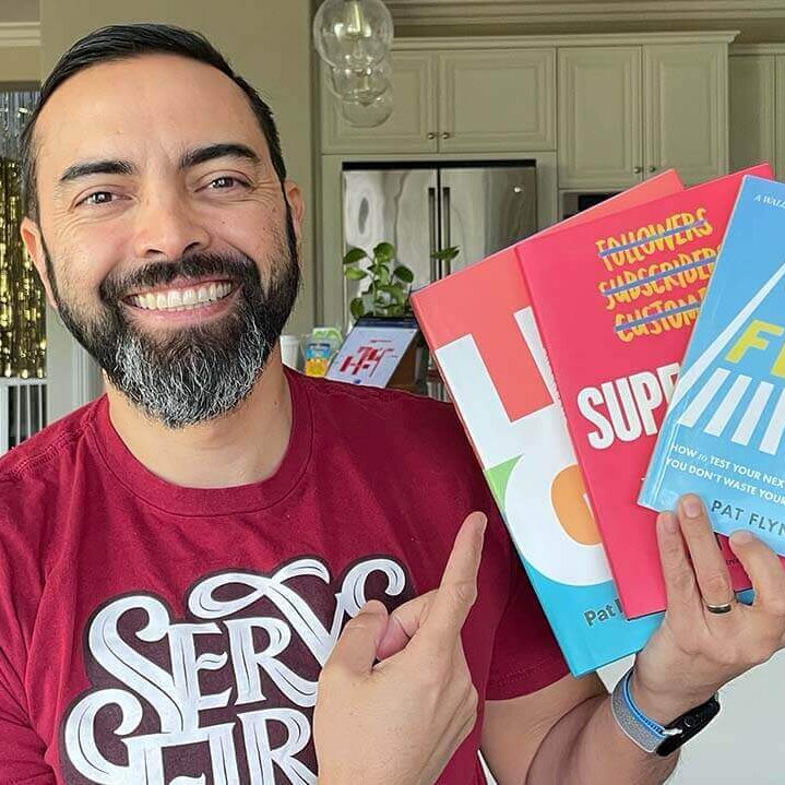 Pat Flynn holding up three of his books
