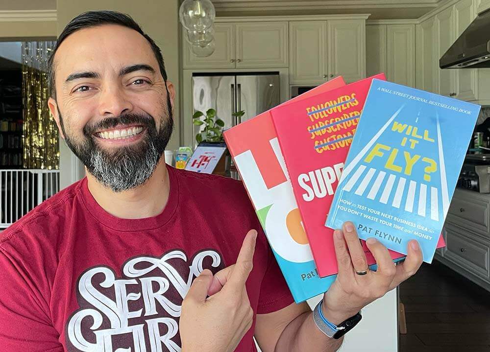 Pat Flynn holding up three of his books