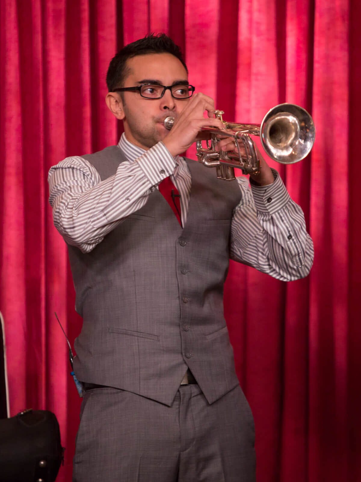 Pat Flynn playing his trumpet on stage during a speech