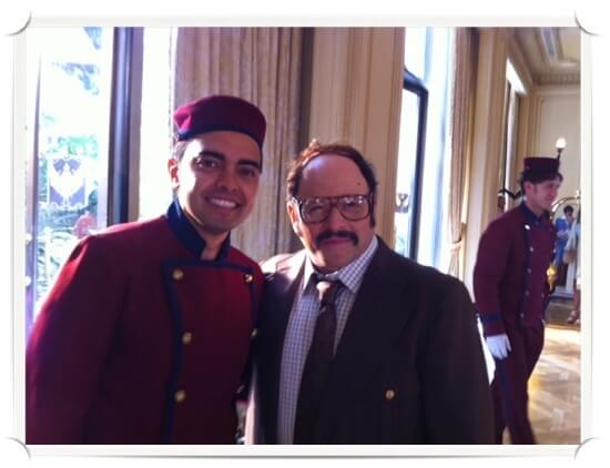 pnj Pat in bellboy uniform, posing with Jason Alexander, who is rocking a thick mustache
