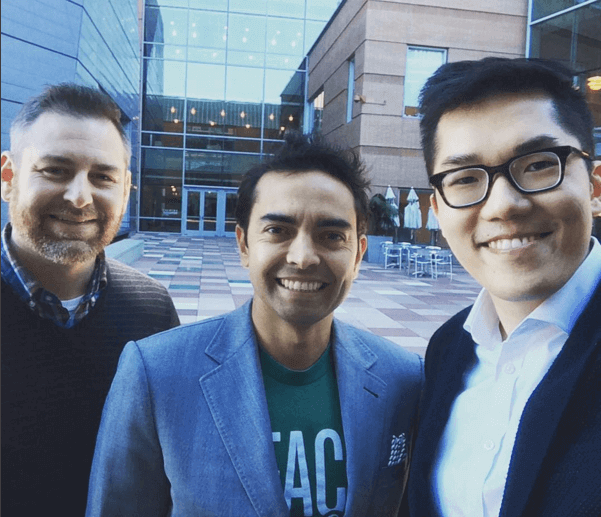 Pat, Nathaniel, and Huei-Yuan standing together for a selfie in a courtyard