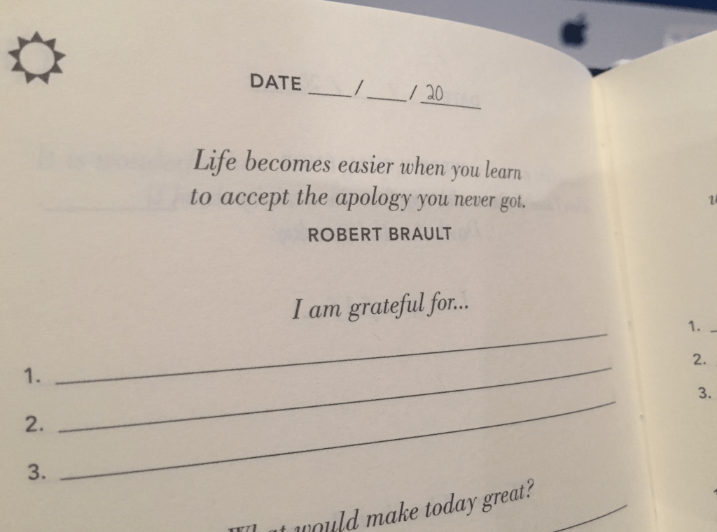 Image of the journal with a fill-in-the-date section. Quote at the top: "Life becomes easier when you learn to accept the apology you never got. — Robert Brault"
Then it reads, "I am grateful for..." with space to fill in three things.